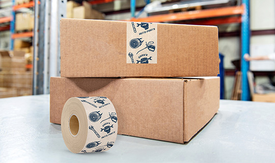 Stack of boxes with packing tape with logo in blue ink